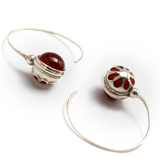 red gemstone in silver or gold earrings