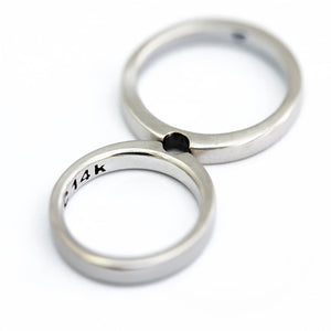 Infinity shape: handcrafted Cadi couples' set, two interlocking 18k silver bands with a black stone, wedding rings.