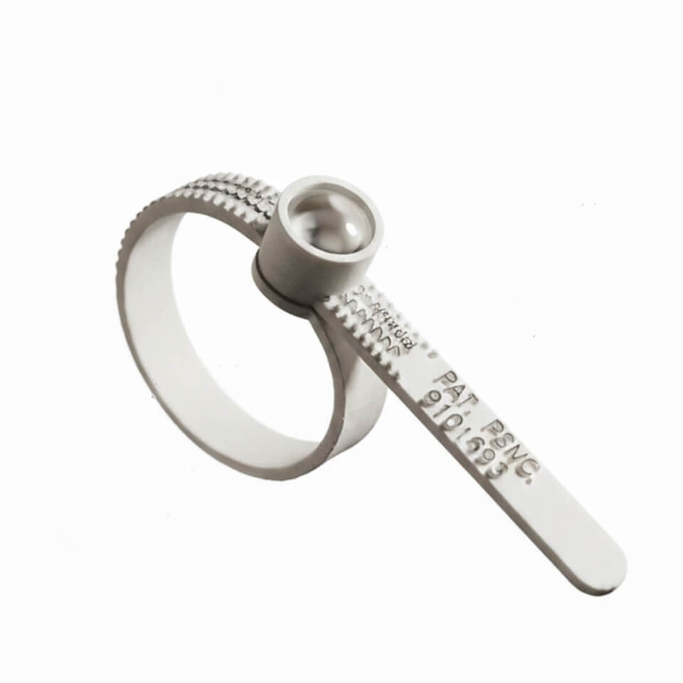 ring sizer on a hand with pink nail polish against a white background
