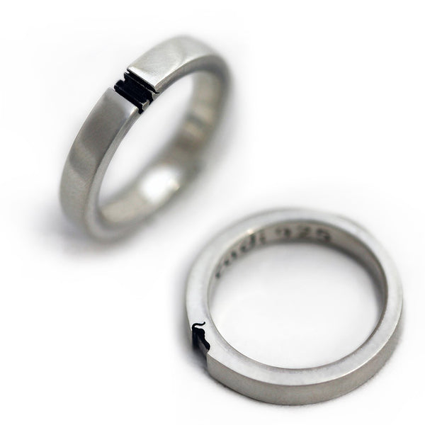 Two silver rings with black accents on a white background