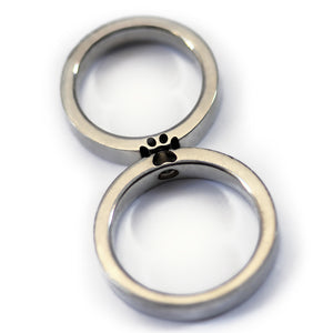 Two paw print couple rings aligned together forming full hidden paw symbol representing bond between partners and shared pet love.
