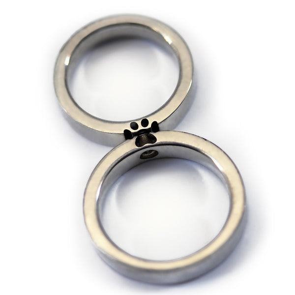 Two paw print couple rings aligned together forming full hidden paw symbol representing bond between partners and shared pet love.