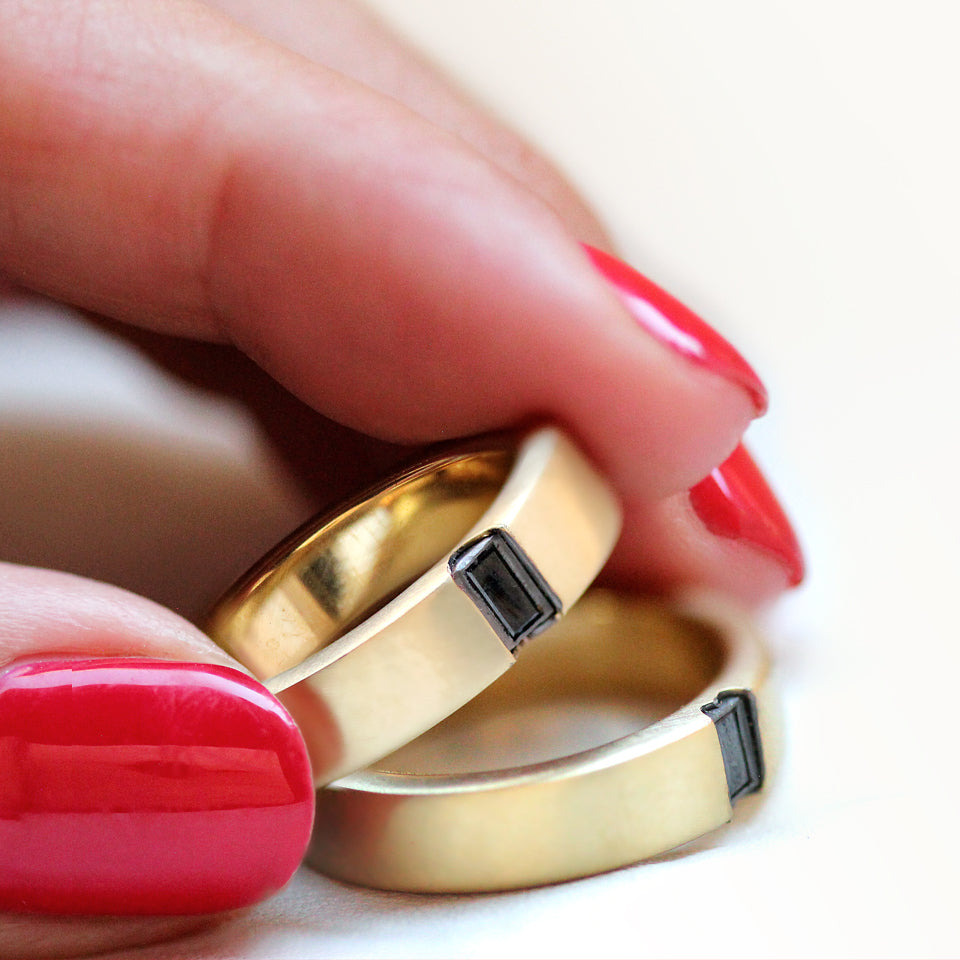 Personalized wedding ring set forming hidden heart when united, black diamond accent bands handmade with professional engraving options, artisan wedding jewelry Barcelona