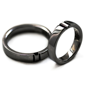 Black rhodium his and hers rings displayed separately showing split paw print elements that form complete symbol when both rings connect.