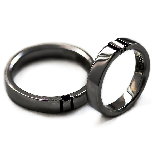 Black rhodium his and hers rings displayed separately showing split paw print elements that form complete symbol when both rings connect.