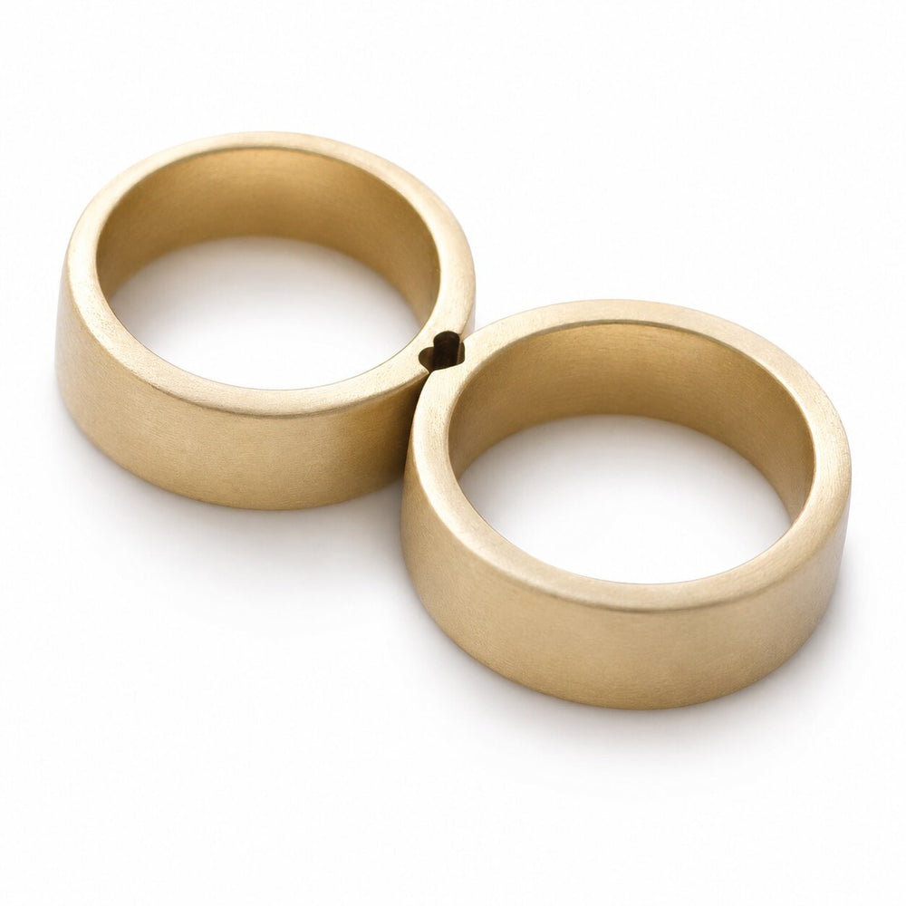 Cadi matching gold rings placed together, showing the  heart-shaped connection between the two bands