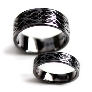 Black rhodium plated Celtic braided his and hers wedding rings featuring polished silver scroll pattern with black hot enamel inlay
