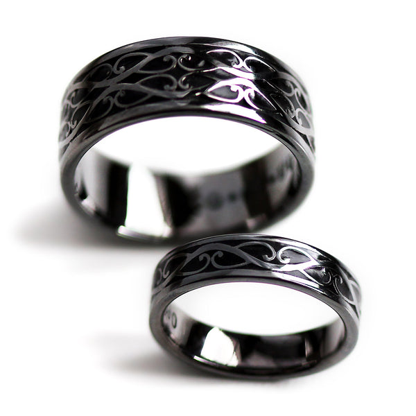 Black rhodium plated Celtic braided his and hers wedding rings featuring polished silver scroll pattern with black hot enamel inlay