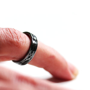 Close up of black rhodium plated Celtic wedding ring set with silver braided pattern and black hot enamel detailing
