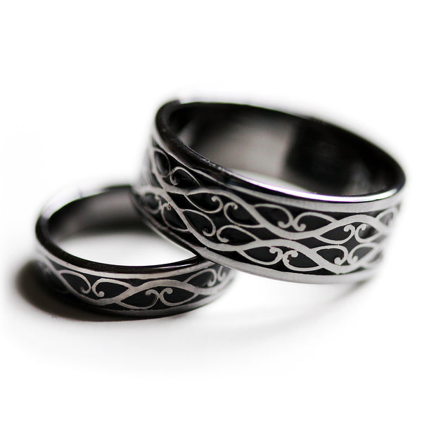 Pair of black rhodium Celtic wedding rings showing contrasting silver braid design with black hot enamel background