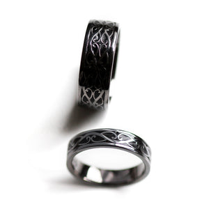 Lifestyle view of matching black rhodium Celtic wedding rings worn on hands featuring braided silver motif and black hot enamel inlay