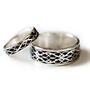 Two tone Celtic wedding ring set showing detailed silver braided motif with black hot enamel background