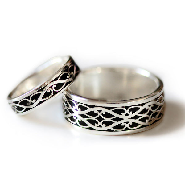 Two tone Celtic wedding ring set showing detailed silver braided motif with black hot enamel background