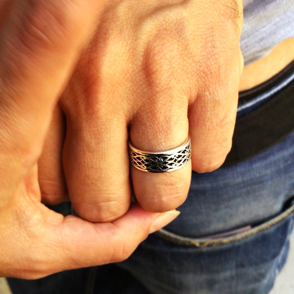 Sterling silver Celtic braided wedding bands worn on hand featuring intricate braid design and black hot enamel inlay
