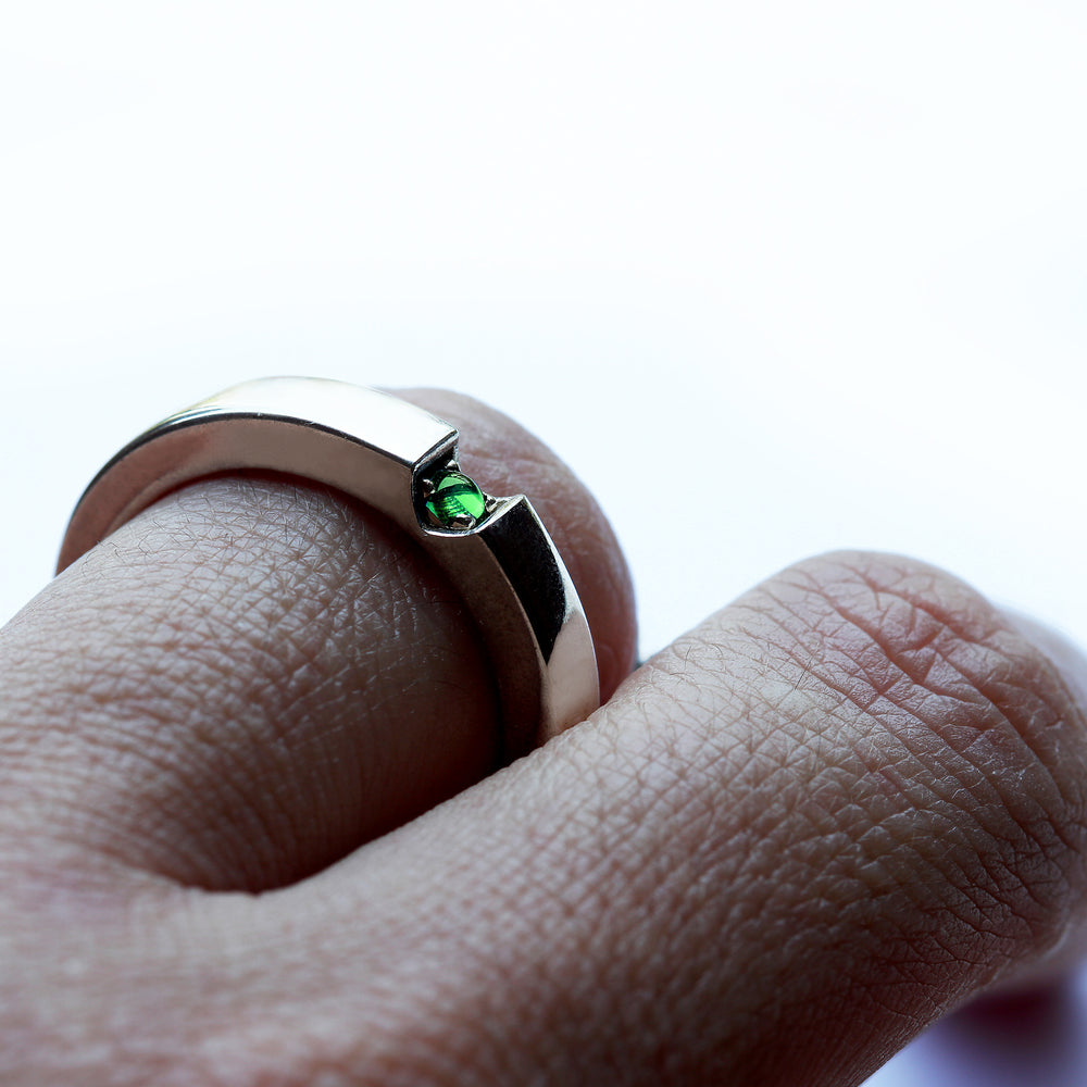 Green tsavorite garnet wedding band with heart shaped gemstone detail, polished white gold couple ring worn on hand, custom engagement rings Barcelona
