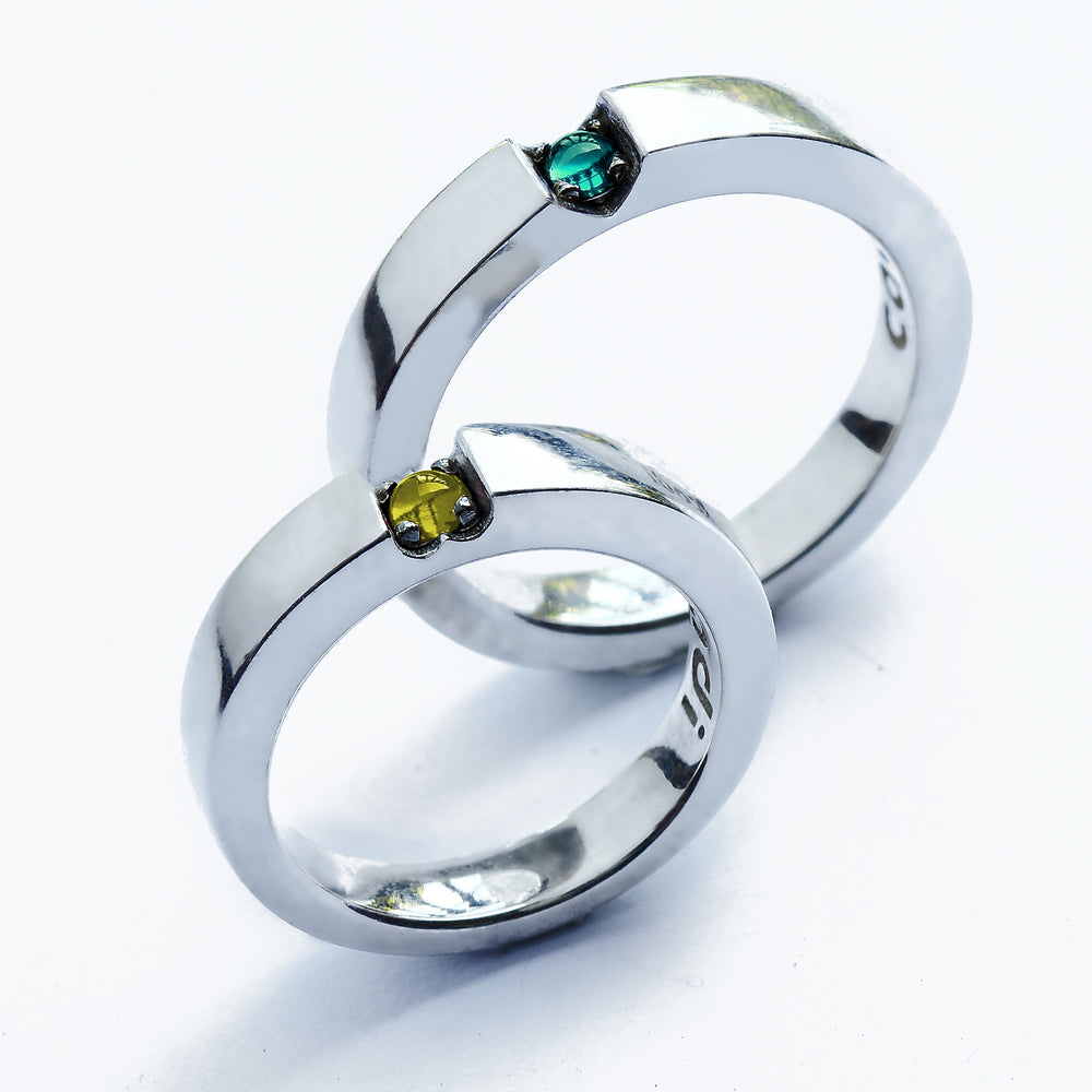 Green tsavorite garnet wedding band with heart shaped gemstone detail, polished white gold couple ring worn on hand, custom engagement rings Barcelona
