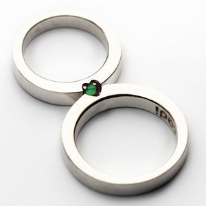 White gold wedding band set with hidden heart tsavorite gemstone, custom couple rings connect to reveal green heart symbol, artisan crafted Barcelona