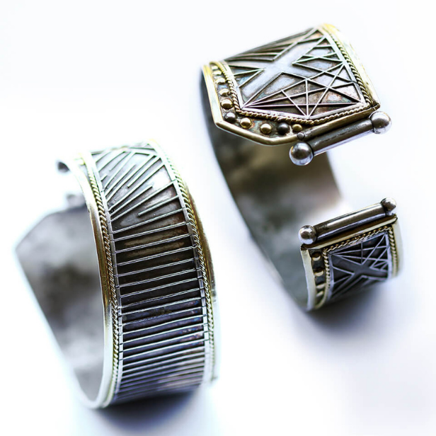 Two silver cuff bracelets with geometric designs on a white background