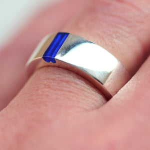 white gold shiny finish ring with a blue enamel in half heart negative space locaited  on a finger
