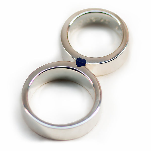 Matching wedding bands in shiny white gold with darckt blue enamel heart revealed when rings connect.