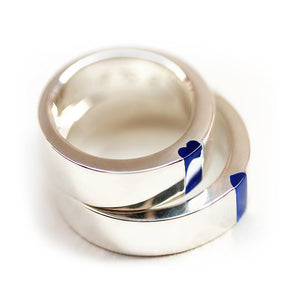 Shiny white gold matching wedding bands with dark blue enamel stripe and hidden heart for couple rings.