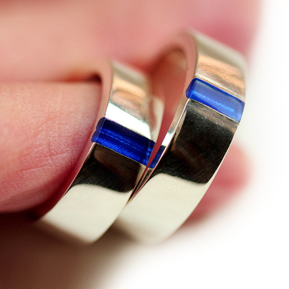 Matching wedding bands in shiny white gold with darckt blue enamel heart revealed when rings connect.