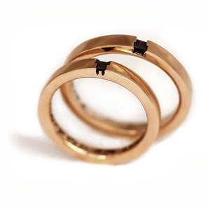 Two rose gold matching wedding bands stacked and slightly flipped to demonstrate the reversible dual animal concept revealing both fox and bunny symbolism.