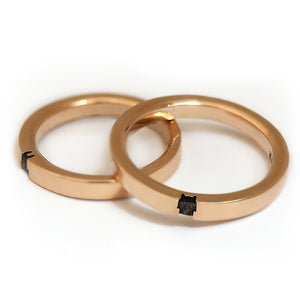 Matching rose gold couple rings aligned to reveal the full bunny silhouette formed through the negative space when both rings are positioned together.