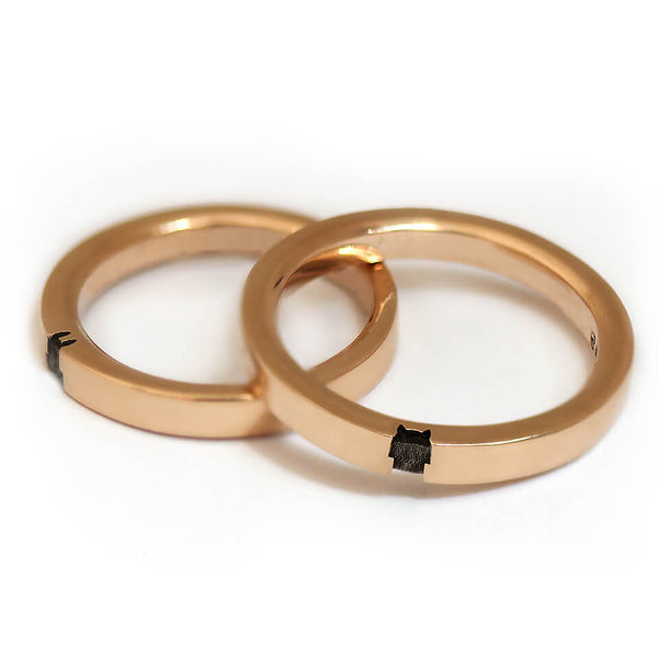 Matching rose gold couple rings aligned to reveal the full bunny silhouette formed through the negative space when both rings are positioned together.