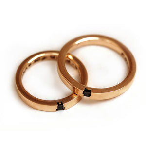 Top view of the matching rose gold rings showing the upper portions of both the fox and bunny silhouettes engraved into the bands.