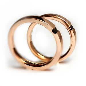 Macro detail of the rose gold dual animal rings highlighting the contrast between polished gold and the recessed design creating the hidden animal silhouettes.
