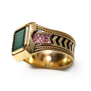 Close up side view of emerald and ruby gold statement ring showing black hot enamel chevron inlay, textured vintage band and rope filigree detailing