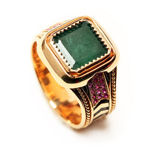 Luxury handcrafted yellow gold emerald statement ring with ruby pavé side details, decorative filigree engraving and geometric black hot enamel chevron band