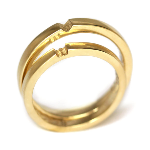 Close view yellow gold interlocking couple rings revealing hidden heart symbol when joined