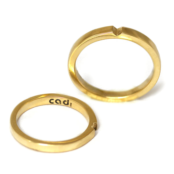 Yellow gold hidden heart wedding rings stacked together, symbolic matching couple bands