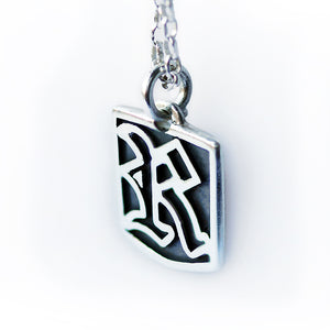 Silver necklace gothic initial letter pendant on a white background