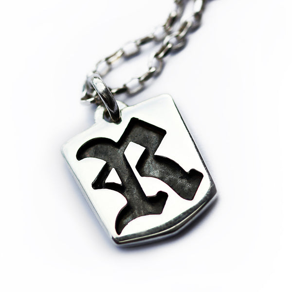 Sterling silver gothic letter pendant necklace featuring raised tag shape with Old English initial cutout and contrast background