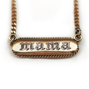 Gold necklace with 'mama' engraving in gothic letters on a white background