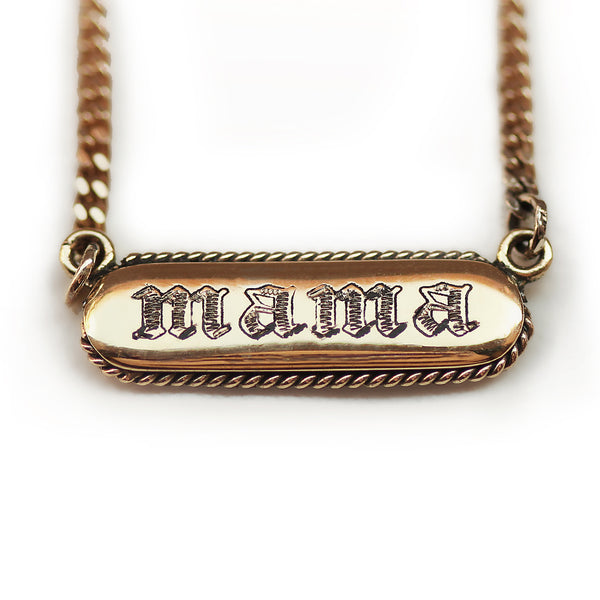 Gold necklace with 'mama' engraving in gothic letters on a white background