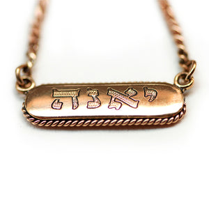 18k Gold tag necklace with gothic letters engraved name on a white background