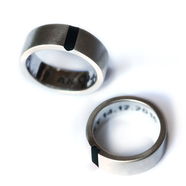 Side angle of matte white gold wedding bands with black enamel, designed to activate your best partnership identity through subtle symbolism.