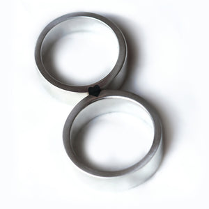 Top-down view of two rings forming a complete black enamel heart, representing a powerful and transformative bond between a couple.  
