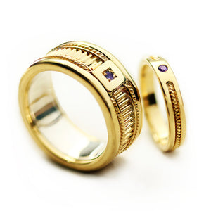 Matching yellow gold wedding bands with purple sapphire stones showcasing fluted texture detailing and filigree rope engraving