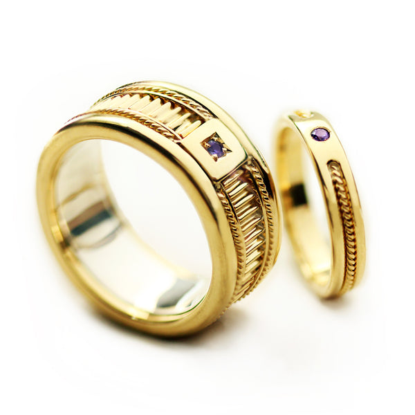 Matching yellow gold wedding bands with purple sapphire stones showcasing fluted texture detailing and filigree rope engraving