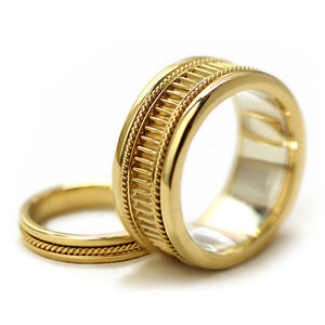 Luxury vintage inspired yellow gold wedding rings featuring intricate filigree detailing, textured band design and purple sapphire centerpiece
