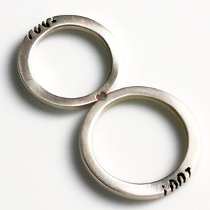 Detail of the "I Do" lettering aligned between the matching wedding rings