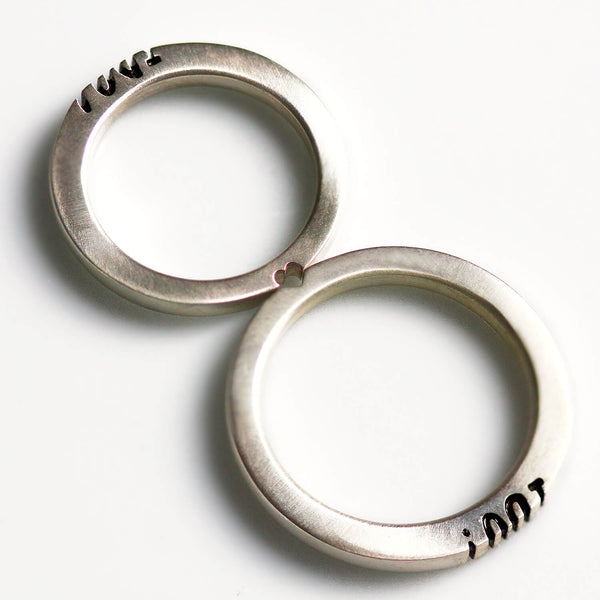 Detail of the "I Do" lettering aligned between the matching wedding rings