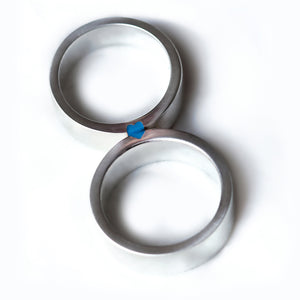 Matching wedding bands in brushed silver or white gold with light blue enamel heart revealed when rings connect.