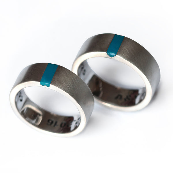 Matching couple wedding bands in נrushed silver  bands with light blue enamel stripe and hidden and concealed heart connection design couple rings. 