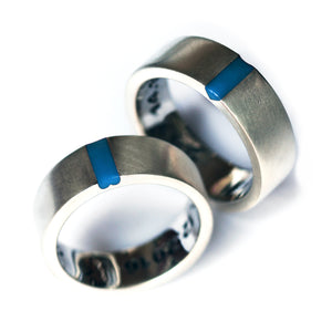 Matching couple wedding bands in silver or white gold featuring light blue enamel accent and concealed heart connection design